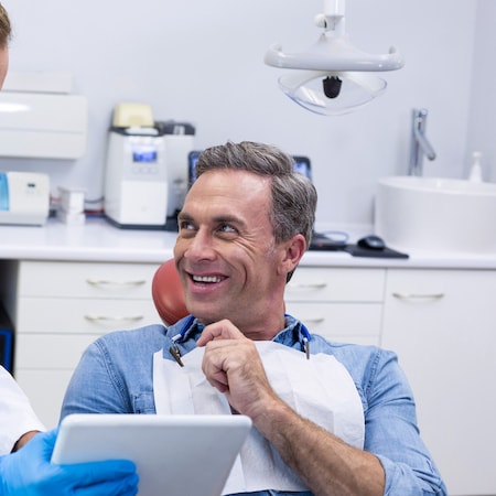 A man looking to his right smiling during a visit to the family dentist